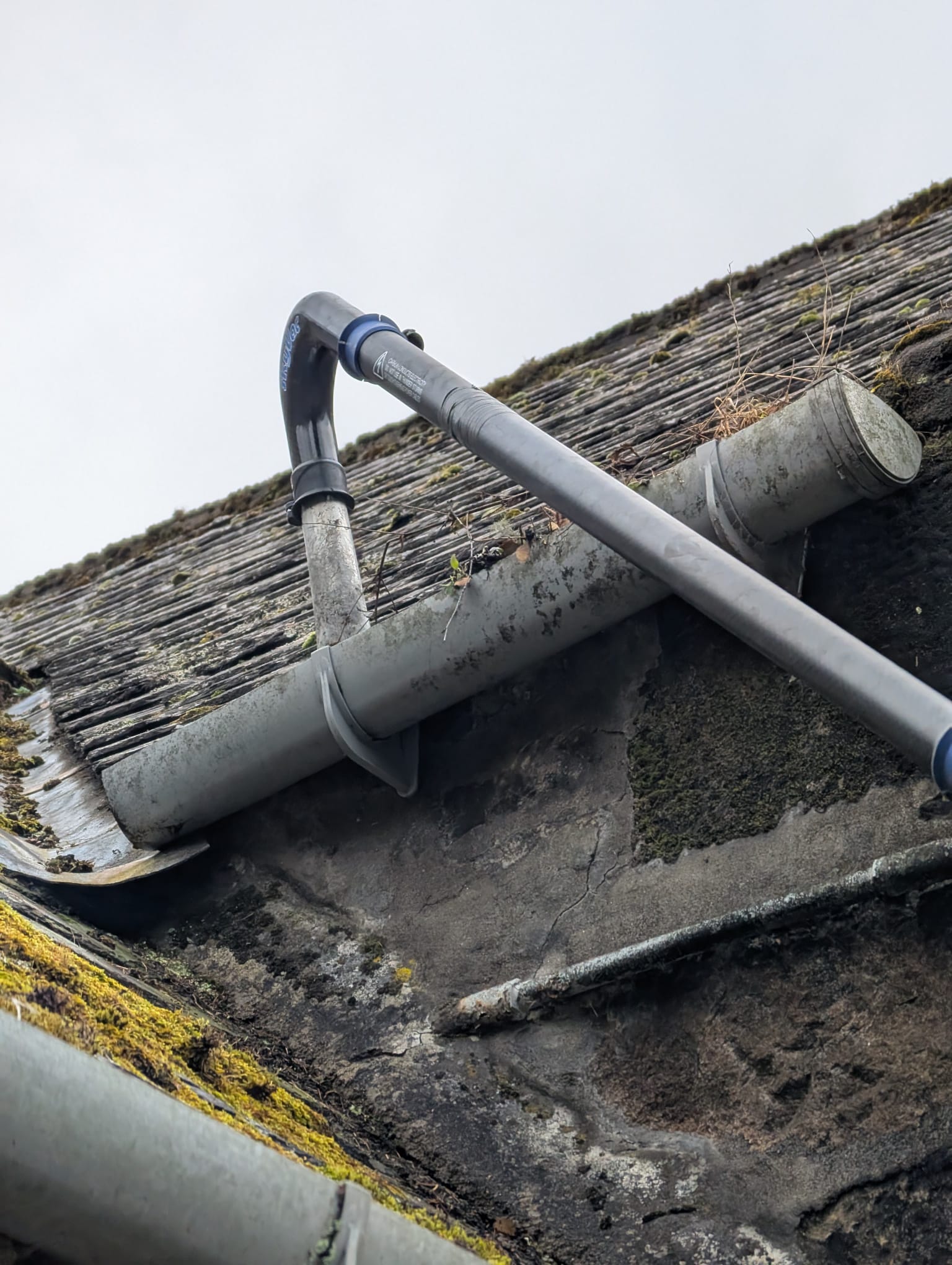 Professional gutter cleaning equipment working on traditional Scottish roof