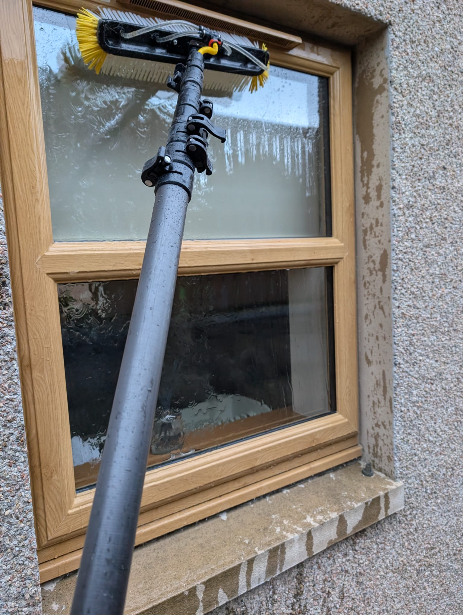 Professional window cleaning work showing water-fed pole technique